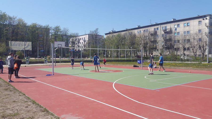 Grupa chłopaków gra na boisku w siatkówkę