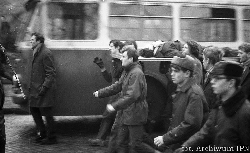 17 grudnia 1970 r. w Gdyni: robotnicy niosą na drzwiach ciało 18letniego Zbyszka Godlewskiego / fot. Archiwum IPN