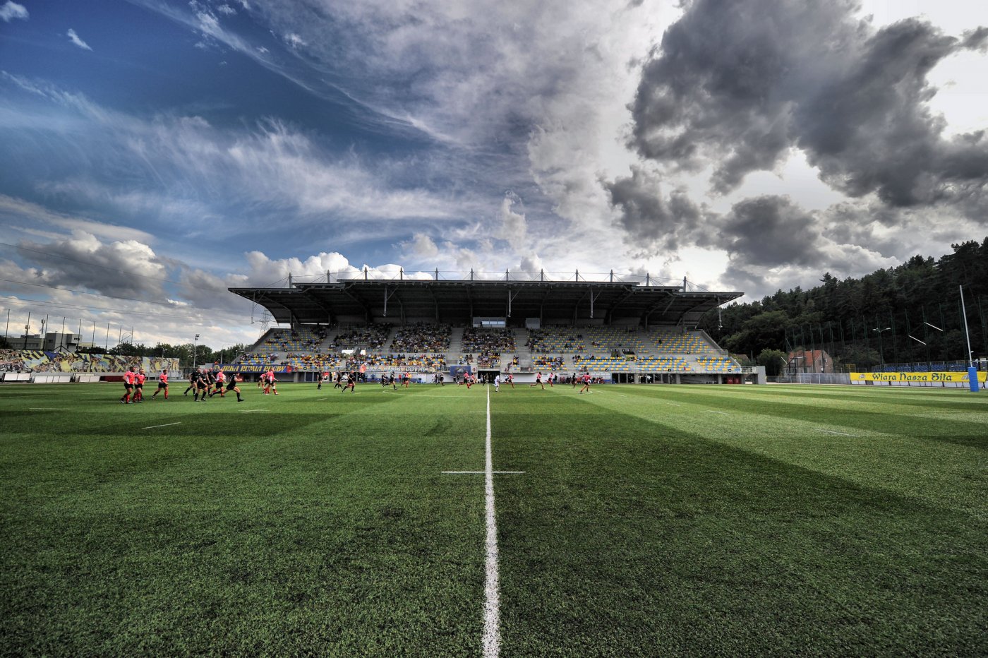 zdjęcie Narodowego Stadionu Rugby w trakcie meczu - widoczna konstrukcja obiektu i zawodnicy w trakcie gry