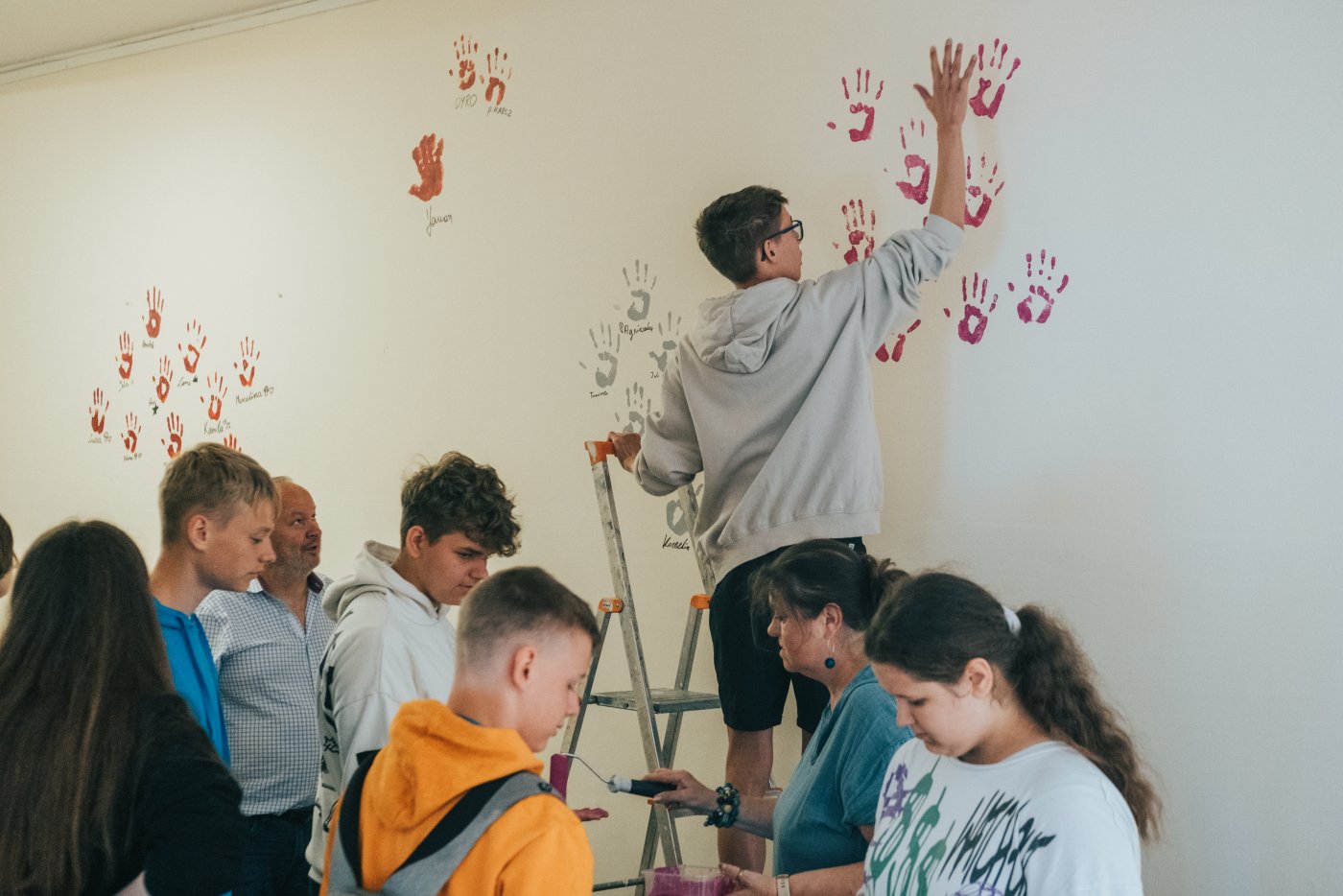 Młodzie ludzie odbijają ręce na ścianie