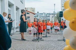 Śpiewające dzieci, z lewej strony budynek