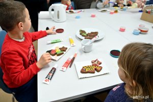 Uczestnicy warsztatów cukierniczych zdobią piernikowe rybki w Spilno Gdynia w ramach „Świątecznej Starowiejskiej”  