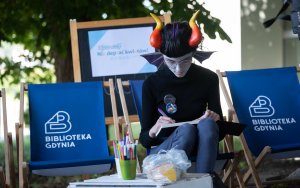 Uczestniczka Minicon-chan „Tanabata” w przebraniu na leżaku z napisem Biblioteka Gdynia