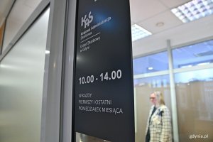 Tabliczka informacyjna z dniami i godzinami otwarcia na drzwiach punktu Urzędu Skarbowego w Gdyni w Gdyńskim Centrum Wspierania Przedsiębiorczości 