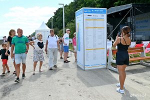 Ludzie spacerujący bulwarem Nadmorskim zapoznają się z programem Pleneru Literackiego