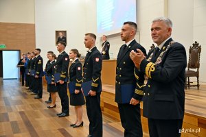 Absolwenci studiów II stopnia Akademii Marynarki Wojennej i rektor-komendant uczelni kadm. prof. dr hab. Tomasz Szubrycht podczas uroczystości wręczenia dyplomów