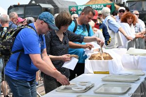 Uczestnicy pikniku z talerzami grochówki