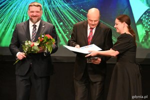 Janusz Jarosiński odbiera Medal im. E. Kwiatkowskiego i kwiaty z rąk prezydent Aleksandry Kosiorek i przewodniczącego RMG Tadeusza Szemiota