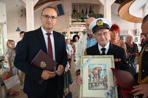 Na pierwszym planie dwóch oficjalnie oficjalnie ubranych mężczyzn