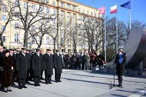 Prezydent Gdyni Aleksandra Kosiorek przemawiająca podczas uroczystości z okazji 99. rocznicy nadania Gdyni praw miejskich. Obok uczestnicy obchodów. W tle pomnik Polski Morskiej