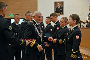 Absolwenci studiów II stopnia Akademii Marynarki Wojennej i rektor-komendant uczelni kadm. prof. dr hab. Tomasz Szubrycht podczas uroczystości wręczenia dyplomów