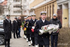 Marynarze niosą wiązanki kwiatów