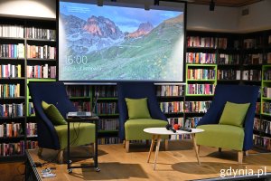 Scena w Bibliotece z Pasją z fotelami, stolikiem i dużym ekranem