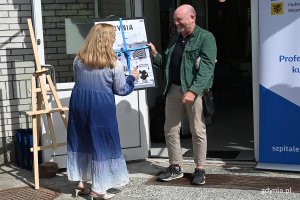 Jolanta Sobierańska - Grenda, prezes Szpitali Pomorskich wręcza gdyński plakat Michaelowi Kennemu z Fundacji im. św. Patryka