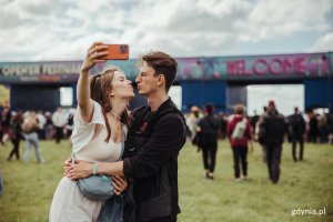 Para robiąca sobie selfie przed bramą Open'era