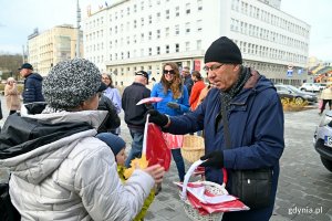 Radny Zenon Roda rozdaje flagi mieszkańcom Gdyni w ramach akcji Radia Gdańsk 