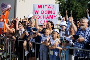 Tłum ludzi witających wracających z misji marynarzy.