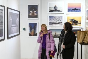 Ludzie oglądają wystawę fotografii w galerii sztuki.