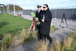 Przedstawiciele Urzędu Morskiego składający kwiaty i znicz podczas uroczystości przed pomnikiem „Tym, co odeszli na wieczną wachtę”