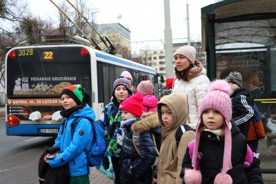 Dzieci na przystanku i trolejbus w tle