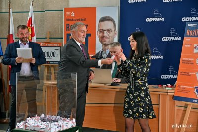 Prezydent Gdyni Wojciech Szczurek przekazuje jeden ze zwycięskich kuponów Natalii Zapale - przedstawicielce komisji nadzoru loterii z firmy Gratifica Promotions // fot. Magdalena Czernek