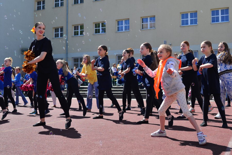 Tańcząca grupa dziewcząt, w powietrzu unoszą się bańki, na pierwszym planie widać dziewczynkę z przedszkola