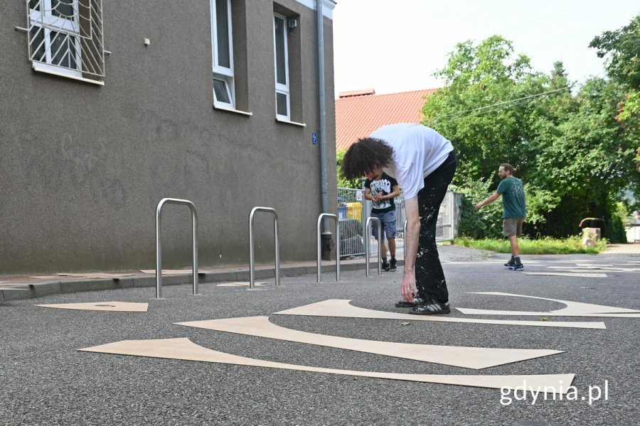 Jeden z artystów układający szablon, z którego powstanie mural