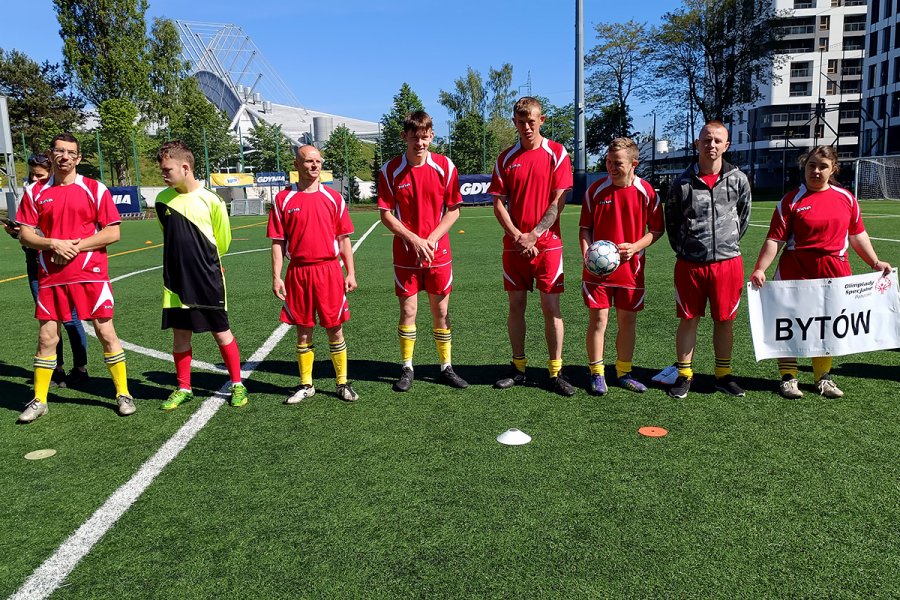 Młodzież w strojach sportowych z banerem w rękach.