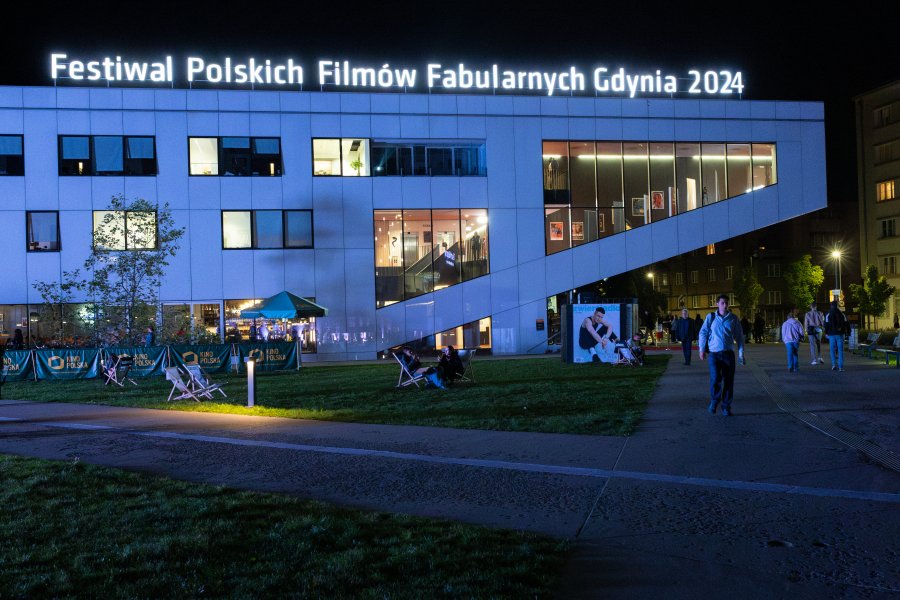 Wieczorny widok na Gdyńskie Centrum Filmowe i podświetlony na nim napis: Festiwal Polskich Filmów Fabularnych Gdynia 2024