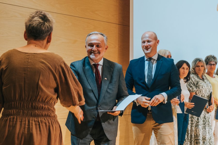 Na scenie dwóch prezydentów, prezydent gratuluje poprzez podanie ręki pani dyrektor