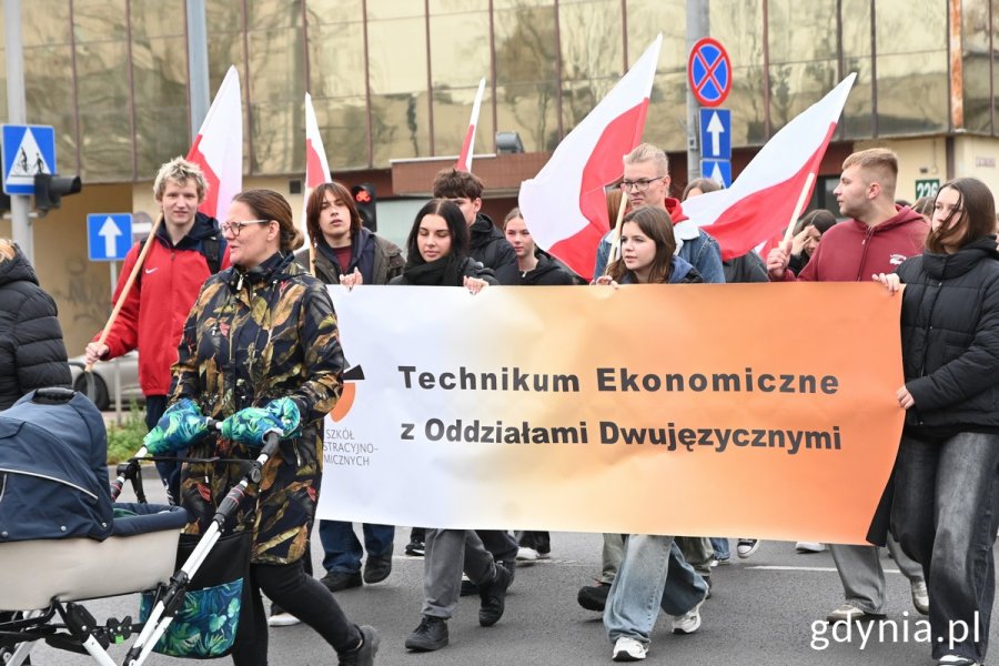 Uczniowie idący w paradzie trzymają transparent: Technikum Ekonomiczne