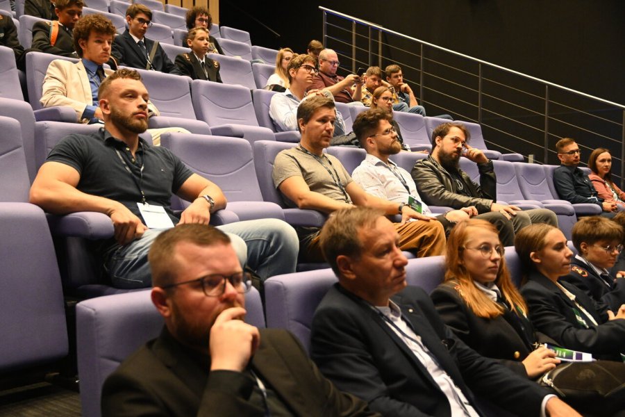 Ludzie siedzą na publiczności sali konferencyjnej.