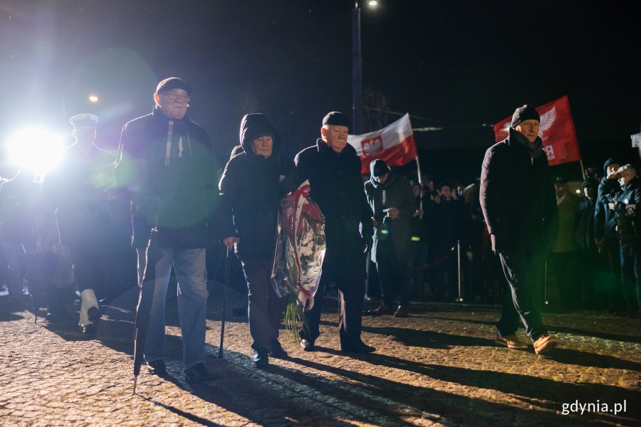 Reprezentacja uczestników strajku, czterej mężczyźni składają wieniec pod Pomnikiem Ofiar Grudnia '70