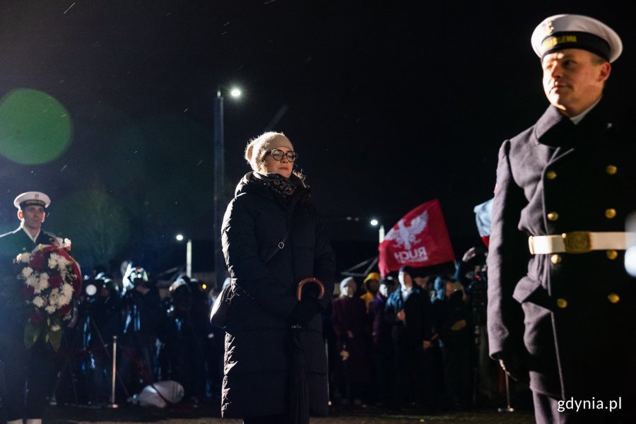 Kobieta oddaje hołd ofiarom przed pomnikiem