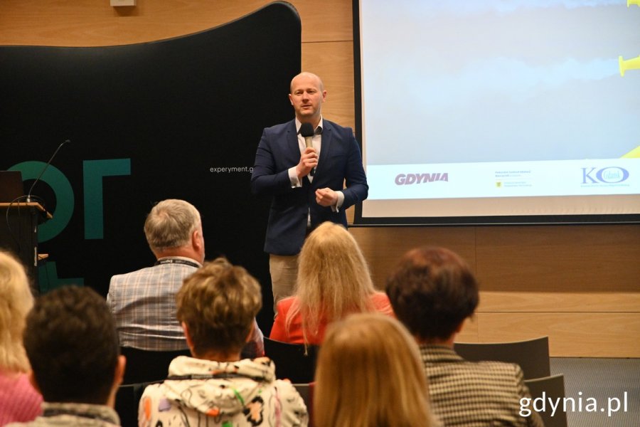 Przemawiający wiceprezydent, na pierwszym planie widać publiczność, w tle ekran rzutnika