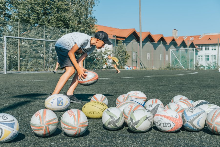 Chłopiec z piłkami do rugby