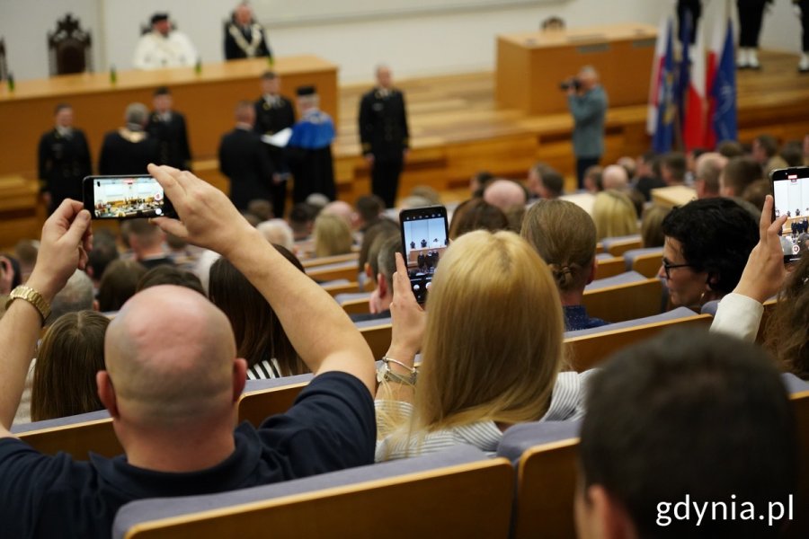 Rodziny świętujących podchorążych robią im zdjęcia telefonami