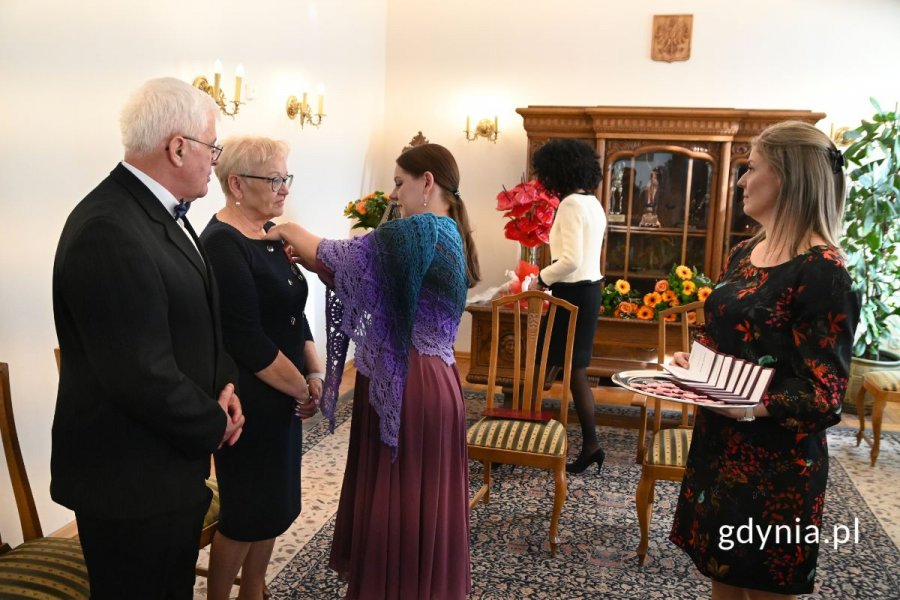 Prezydent Aleksandra Kosiorek przypinająca medal elegancko ubranej seniorce