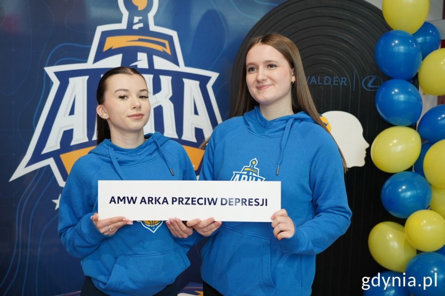 Dwie dziewczynki trzymają kartkę z napisem: AMW Arka przeciw depresji