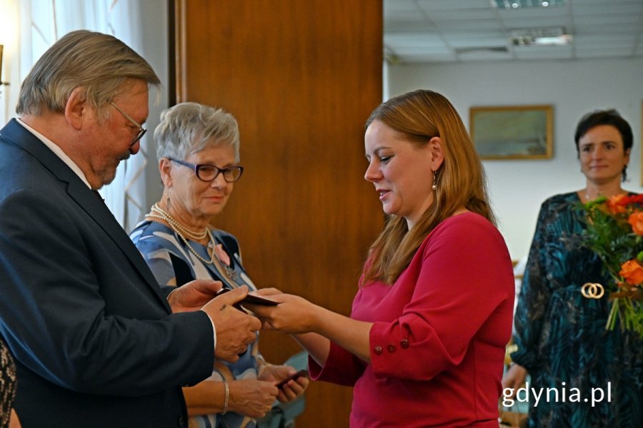 Prezydent Aleksandra Kosiorek wręcza medal jubilatom 