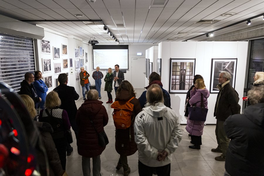 Ludzie oglądają wystawę fotografii w galerii sztuki.