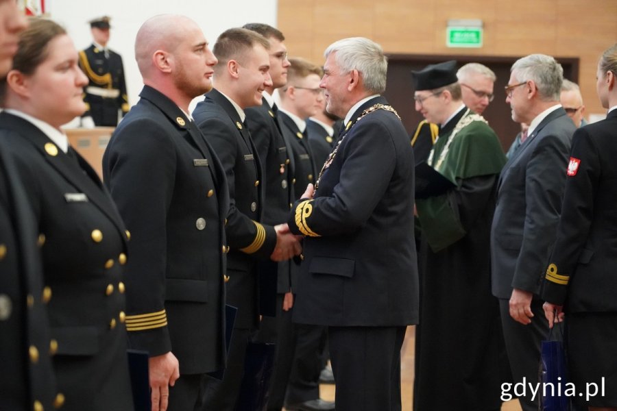 Studenci odbierają dyplomy i gratulacje od władz uczelni