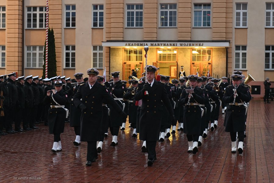 Żołnierze marynarki Wojennej defiluja przed budynkiem/