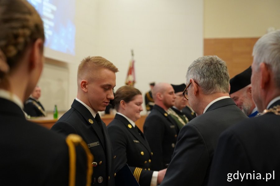 Studenci odbierają dyplomy i gratulacje od władz uczelni