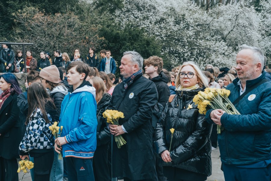 Uczniowie i nauczyciele z żonkilami