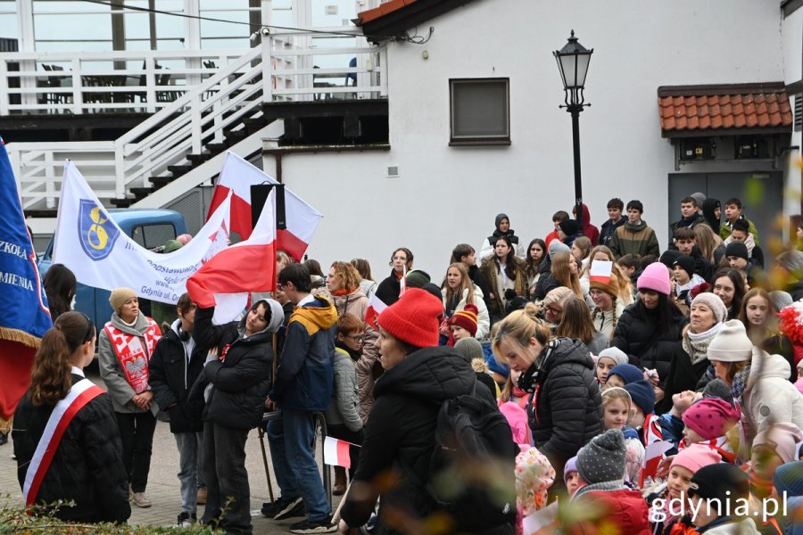 Uczestnicy parady stoją przy Tawernie Orłowskiej