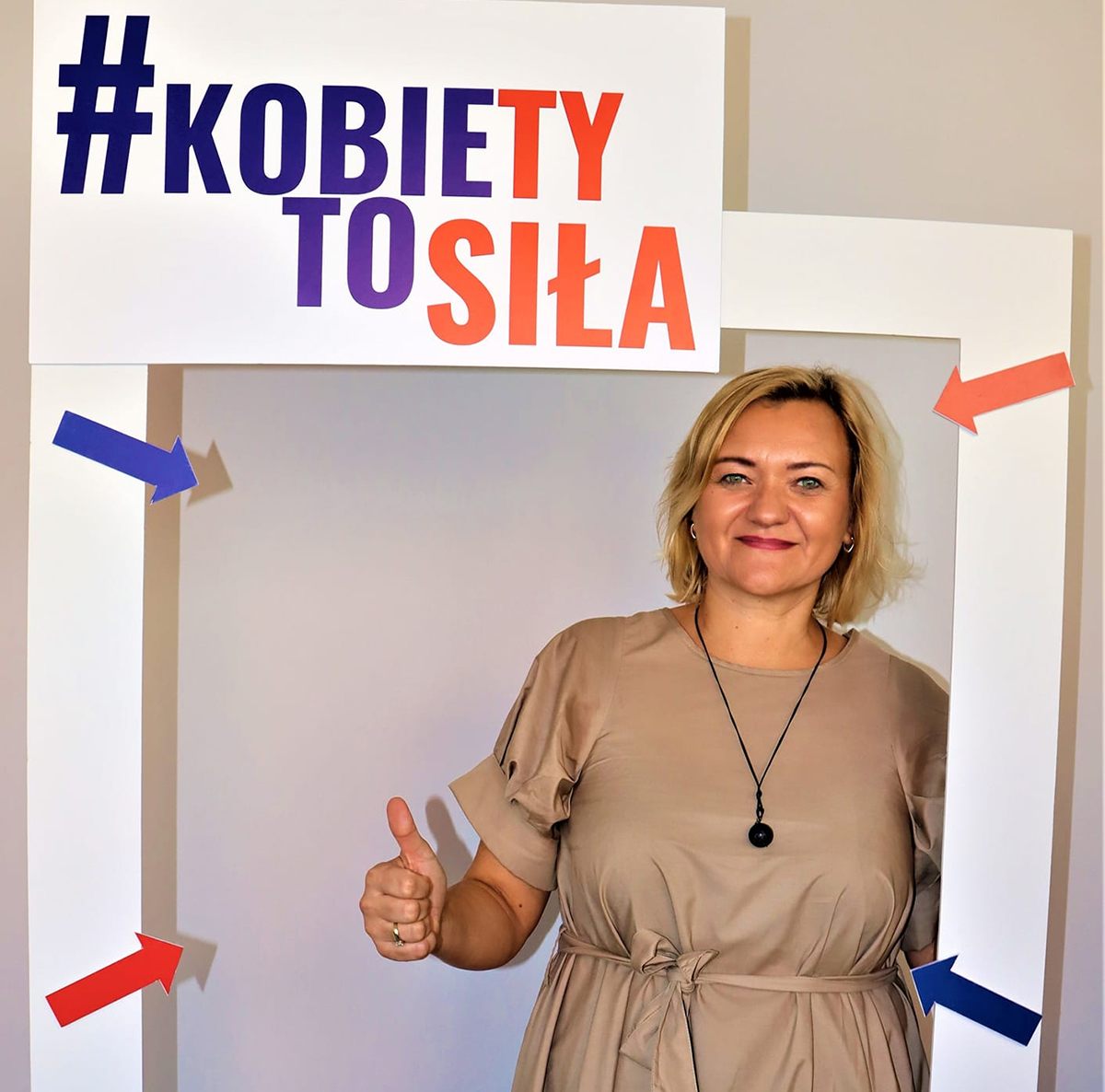 Kobieta stoi w ramce z napisem "Kobiety to siłą"