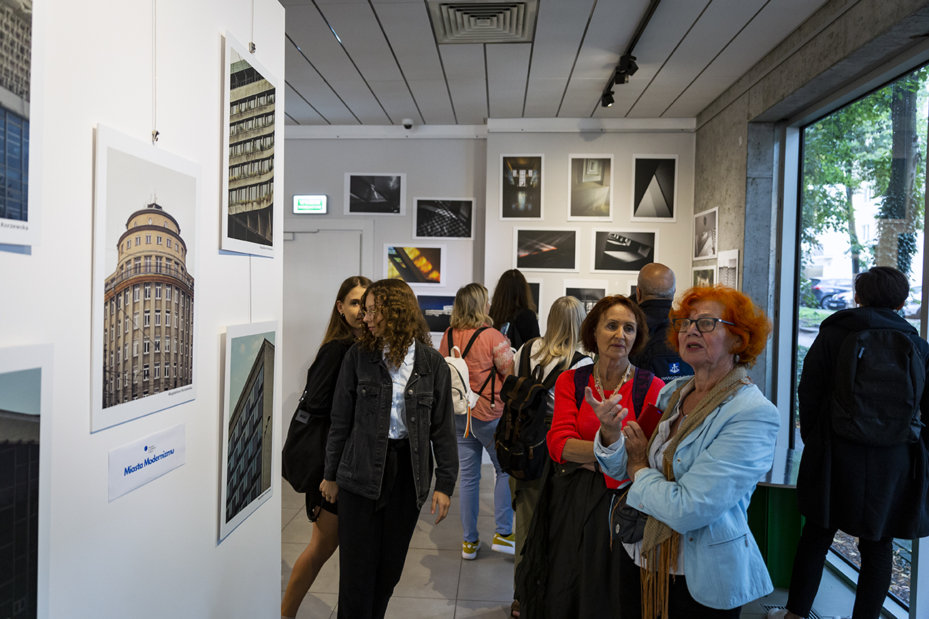 Ludzie oglądają wystawę fotografii w galerii.