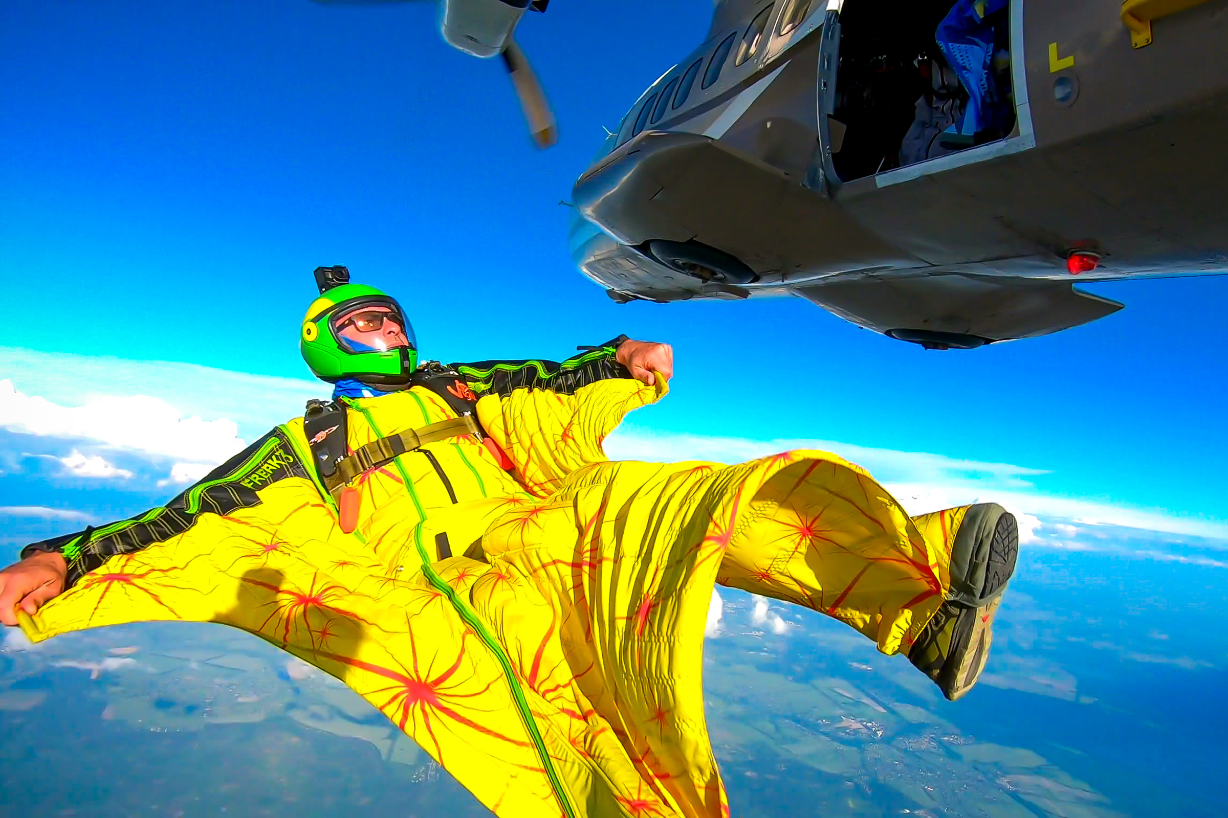 Skoczek w żółtym kombinezonie wingsuit. // fot. mat. prasowe