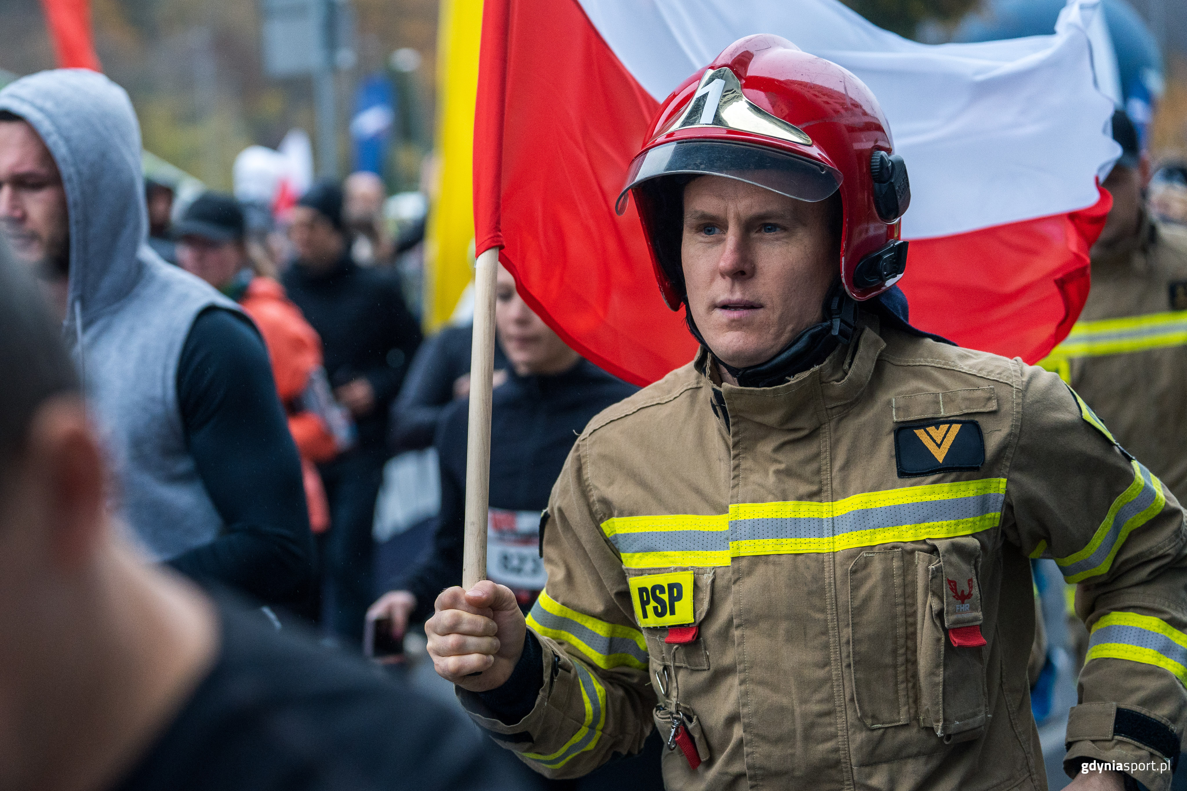 strażak z flagą w stroju strażackim